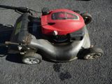 une tondeuse à gazon sur laquelle est posé un casque rouge