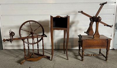 Trois machines à filer anciennes sont posées à côté d'une porte de garage