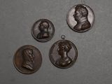 quatre médaillons en bronze représentant des hommes et des femmes sur un fond gris