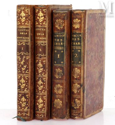 three old books are stacked on top of each other on a white surface