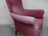 a pink chair sitting against a white wall