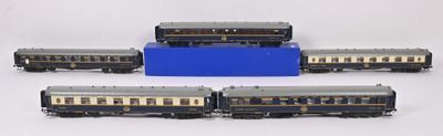 four model trains are lined up in a row on a white surface