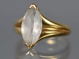un gros plan d'une bague en or sertie d'un quartz transparent