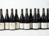 six bouteilles de vin sont alignées sur une table