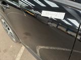 a black car with a sticker on it parked in a parking lot