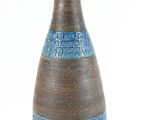 un vase marron et bleu surmonté d'une lampe