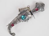 a silver dagger with a blue and red stone on it