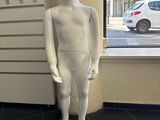un mannequin blanc debout devant une vitrine