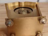 a gold clock sitting on a wooden table