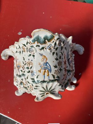 une table rouge avec une chaise rouge et un vase blanc posé dessus