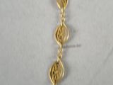 a close up of a gold necklace on a white surface