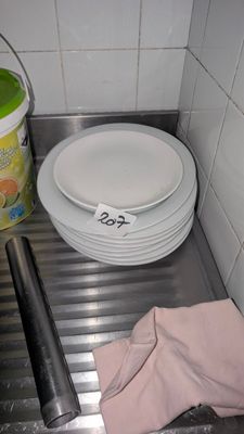 une pile d'assiettes posée sur une étagère métallique dans une cuisine