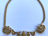 a close up of a necklace on a white surface