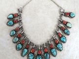 un collier orné de pierres turquoise et rouges sur fond blanc