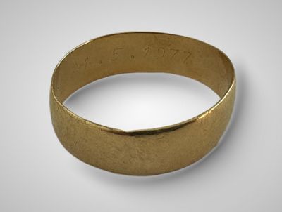 gros plan d'une bague en or sur une surface blanche