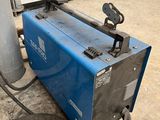 an image of a blue welding machine sitting on top of a cement floor