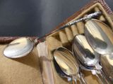 several spoons and spoon rest in a leather case on a table