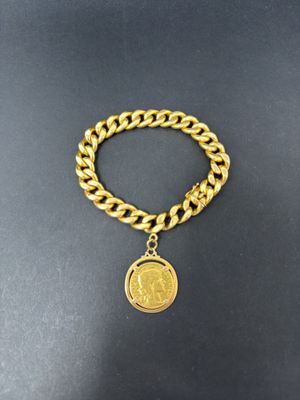 a gold chain bracelet with a coin charm on it