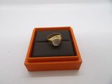 an orange box with a ring inside of it on a white surface