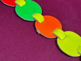 a close up of a colorful bracelet on a purple surface