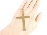 a person holding a gold cross on their hand
