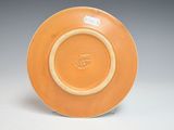 yellow and white plate with a brown rim on a gray surface