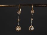 une paire de boucles d'oreilles en or et diamants suspendues à une branche