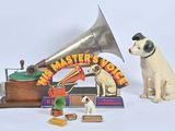 un chien assis à côté d'un gramophone et d'autres objets