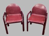 une paire de fauteuils en cuir rouge avec accoudoirs et pieds