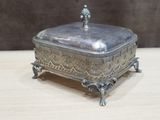 a small silver box with a bird on top of it