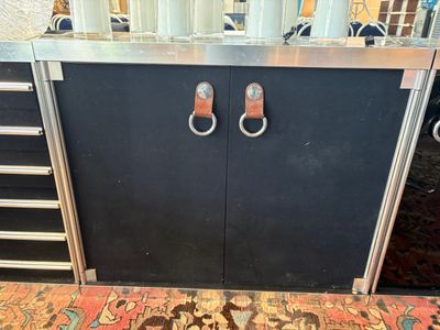 une armoire noire munie de deux poignées métalliques