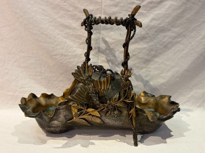 a metal basket with a bird on it on a table