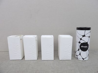 quatre boîtes blanches ornées de motifs en noir et blanc, disposées les unes à côté des autres