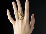 woman ' s hand with a gold ring on it ' s finger
