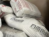 a pile of bags of cement sitting on top of a bed