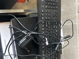 a computer keyboard and mouse on a desk with a lot of wires