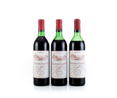 trois bouteilles de vin rouge posées l'une à côté de l'autre sur une surface blanche