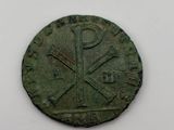 a close up of a coin with a cross on it