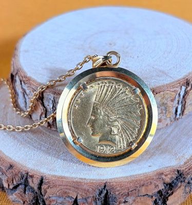 an image of a gold plated necklace with a native indian head on it