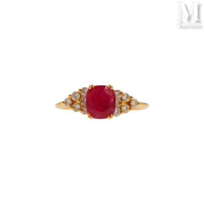 gros plan d'une bague avec une pierre rouge entourée de diamants