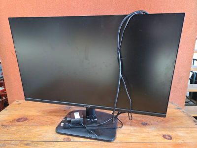 a computer monitor sitting on top of a wooden table