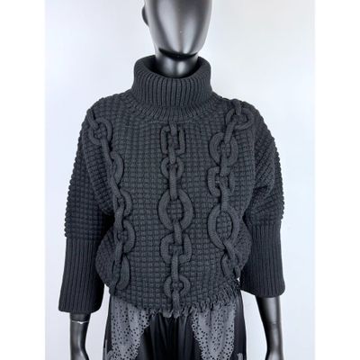un mannequin vêtu d'un pull noir et d'un pantalon noir
