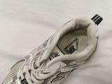adidas running shoes on a bed with a white sheet in the background