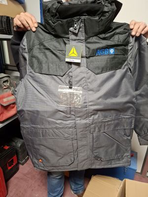 a man that is holding up a jacket in a room