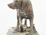 statue of a dog standing on a wooden base on a white background