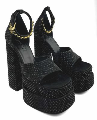 un gros plan sur une paire de sandales noires à talons hauts