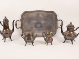 a silver tray with three silver teapots and a tray with a silver tray on it