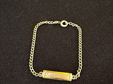 un bracelet plaqué or orné d'une breloque en forme de barre