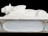 a statue of a cat laying on a bed