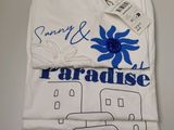 un t-shirt blanc avec une fleur bleue sur le devant
